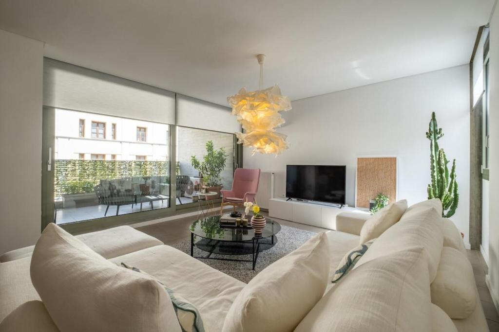 een woonkamer met een witte bank en een tv bij Award-winning White-spot in Athene