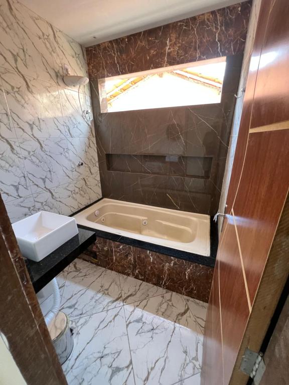 ein Badezimmer mit Badewanne und Waschbecken in der Unterkunft Casa nova para alugar em Campina Grande toda mobiliada in Campina Grande