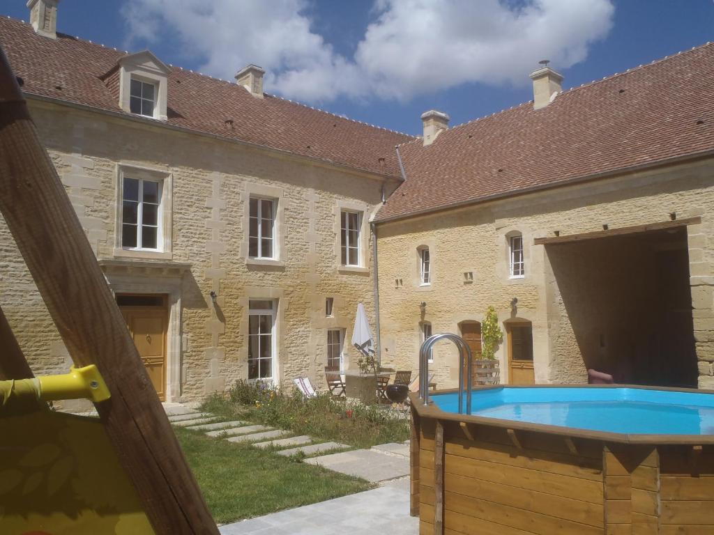 une piscine extérieure en face d'un bâtiment dans l'établissement Le Petit Fort, à Bény-sur-Mer