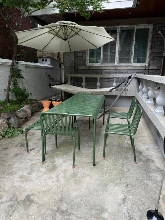 a table and two chairs and an umbrella on a patio at Manoa Garden in Seoul