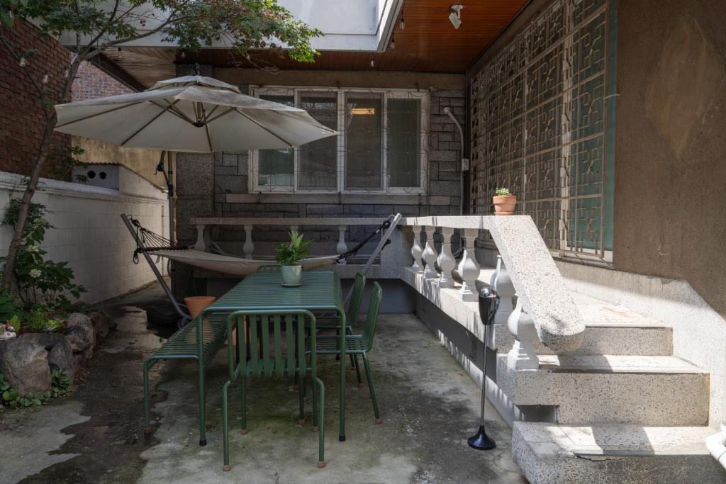 a table and chairs with an umbrella on a patio at Manoa Garden in Seoul