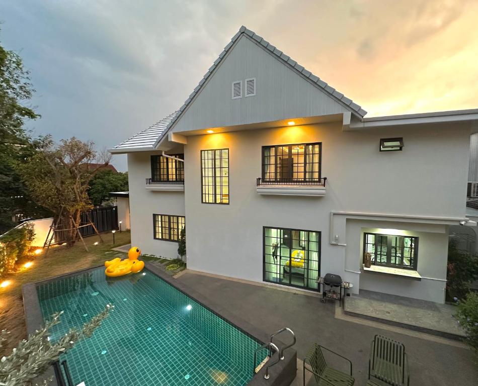 a house with a swimming pool in front of it at Villa Abigail Chiang Mai in Chiang Mai