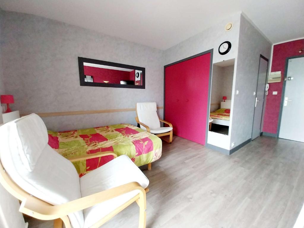 - une chambre avec un lit et deux chaises blanches dans l'établissement Studio confortable avec WiFi, parfait pour 2 personnes - FR-1-553-297, à Balaruc-les-Bains