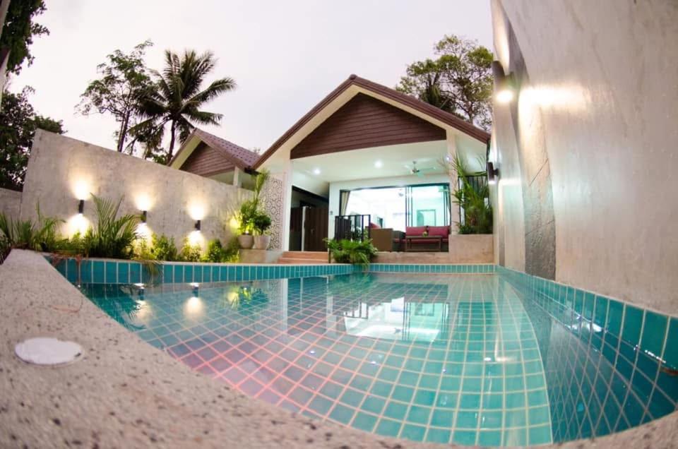 a swimming pool in front of a house at Orchid Pool Villas - Koh Chang in Ko Chang
