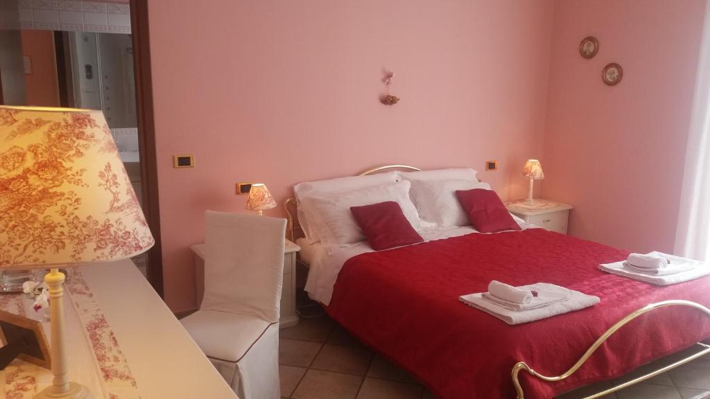 a bedroom with a bed with a red blanket and a chair at Villa Campo dei Fiori in Casciago