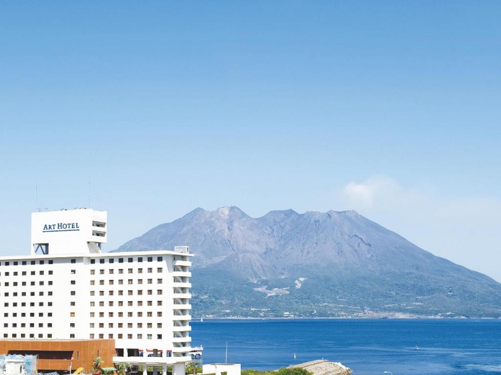 Blick auf ein Hotel mit einem Berg im Hintergrund in der Unterkunft Art Hotel Kagoshima in Kagoshima