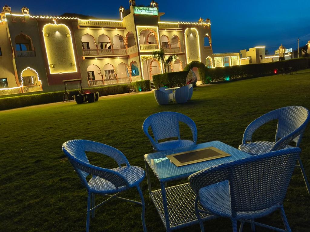 a table and chairs in front of a building at Siddarth Resort - Mountain View with Pool in Pushkar