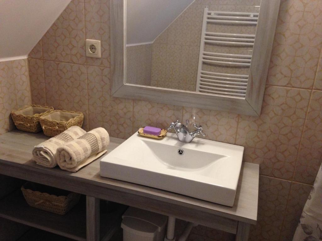 a bathroom with a sink and a mirror and towels at Premium "Vintage" Apartment in Zalaszentmihály