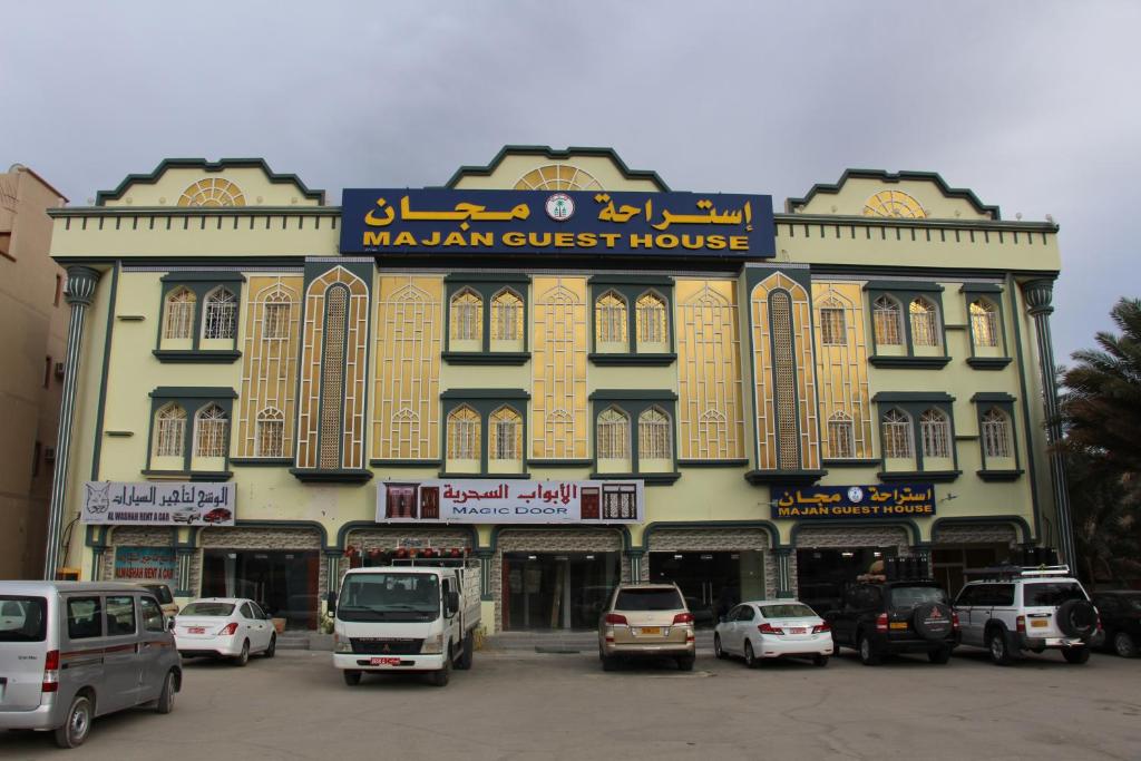 a large building with cars parked in front of it at Majan Guest House L.L.C. in Nizwa