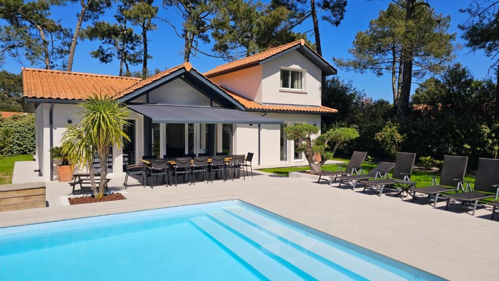 une villa avec piscine et une maison dans l'établissement VILLA PROCHE MER/PISCINE CHAUFFEE ET SECURISEE/CLIMATISATION, à Lacanau-Océan