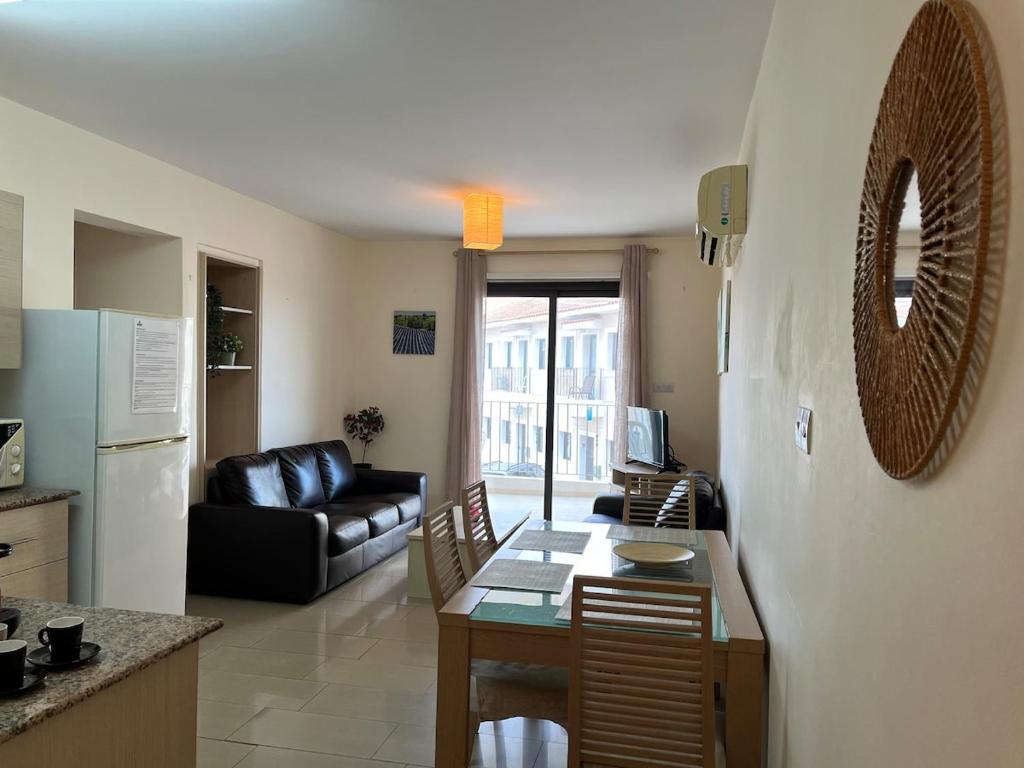 a kitchen and living room with a table and a couch at 2 Bedroom Apartment, Pools, 800m to Beach, Kyklades Resort in Paralimni