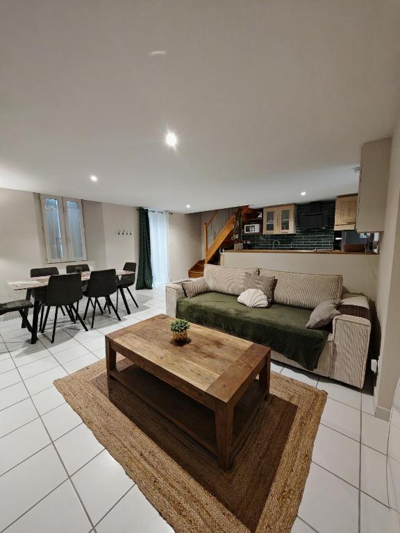 un salon avec un canapé vert et une table dans l'établissement Jolie Maison au 34 centre-ville, à Angoulême