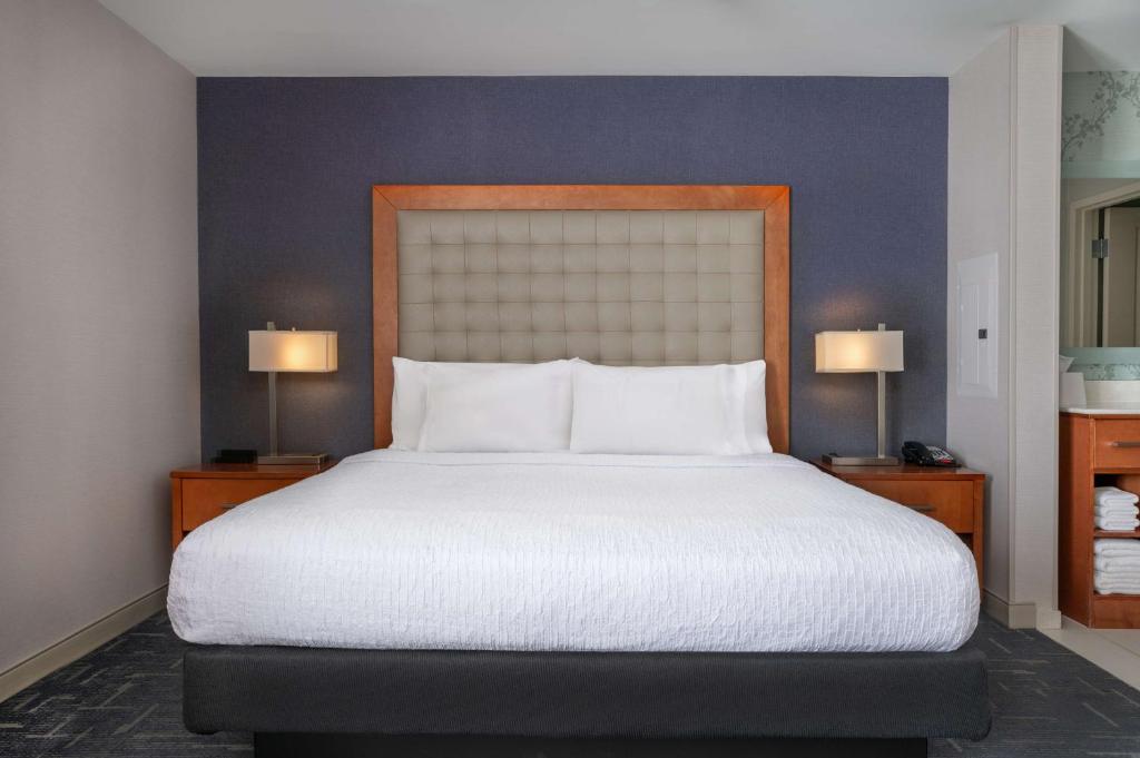 a bedroom with a large bed with two lamps at Homewood Suites by Hilton Gateway Hills Nashua in Nashua