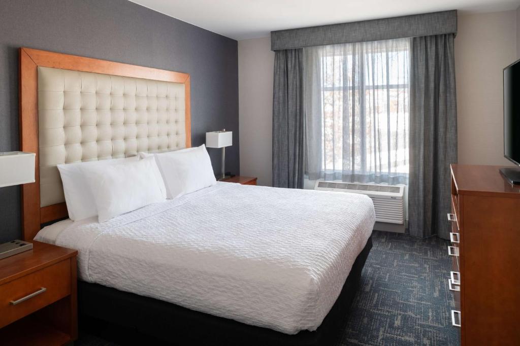 a hotel room with a bed and a window at Homewood Suites by Hilton Gateway Hills Nashua in Nashua