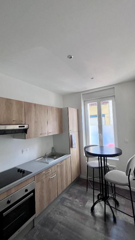 une cuisine avec une table et des chaises et une fenêtre dans l'établissement Studio neuf proche de la mer, à Étaples