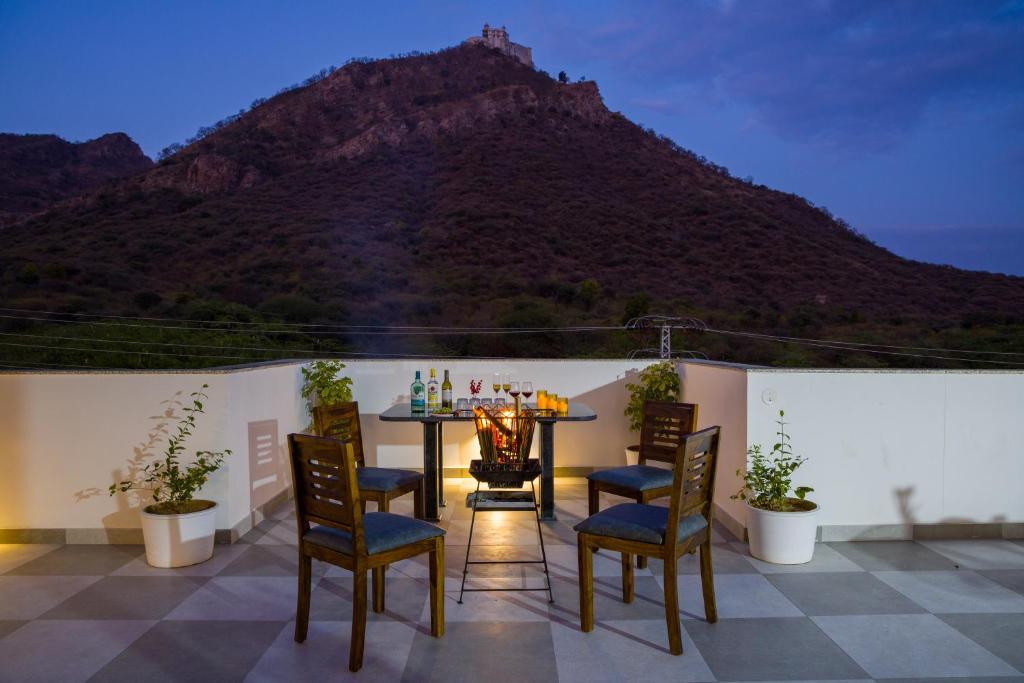 NāiにあるAlaya Stays Kasturi Villa - Pet Friendly 6 BHK with Plunge Poolの山の景色を望むパティオ(テーブル、椅子付)