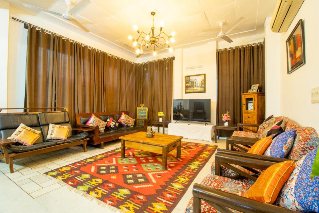 a large living room with couches and a tv at Opulent Antique 6BR Independent Villa in Gurugram in Gurgaon