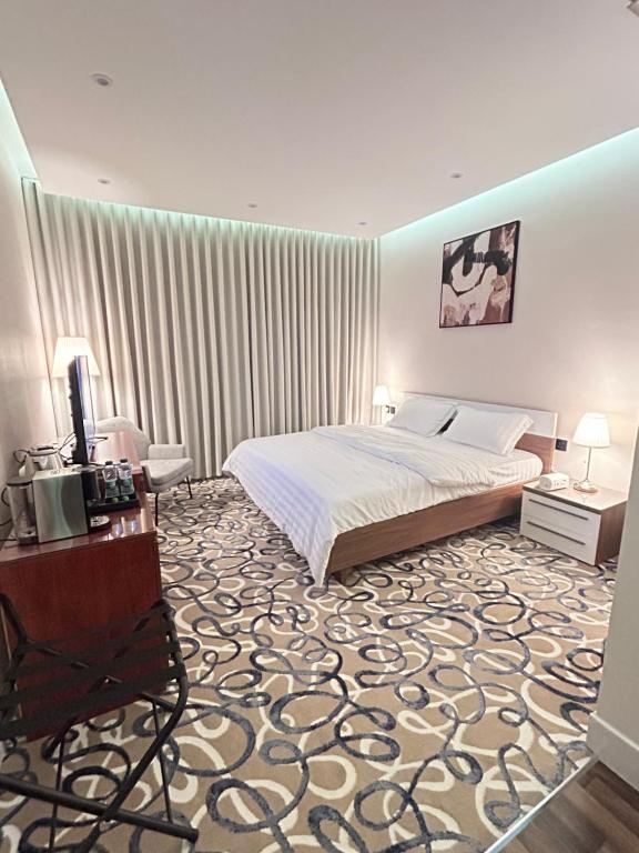 a bedroom with a bed and a table and a chair at غرفه فندقيه فاخره in Riyadh