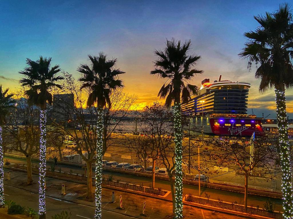 un navire de croisière avec des palmiers au loin dans l'établissement Toulon - Sea View and Coeur de Ville, à Toulon