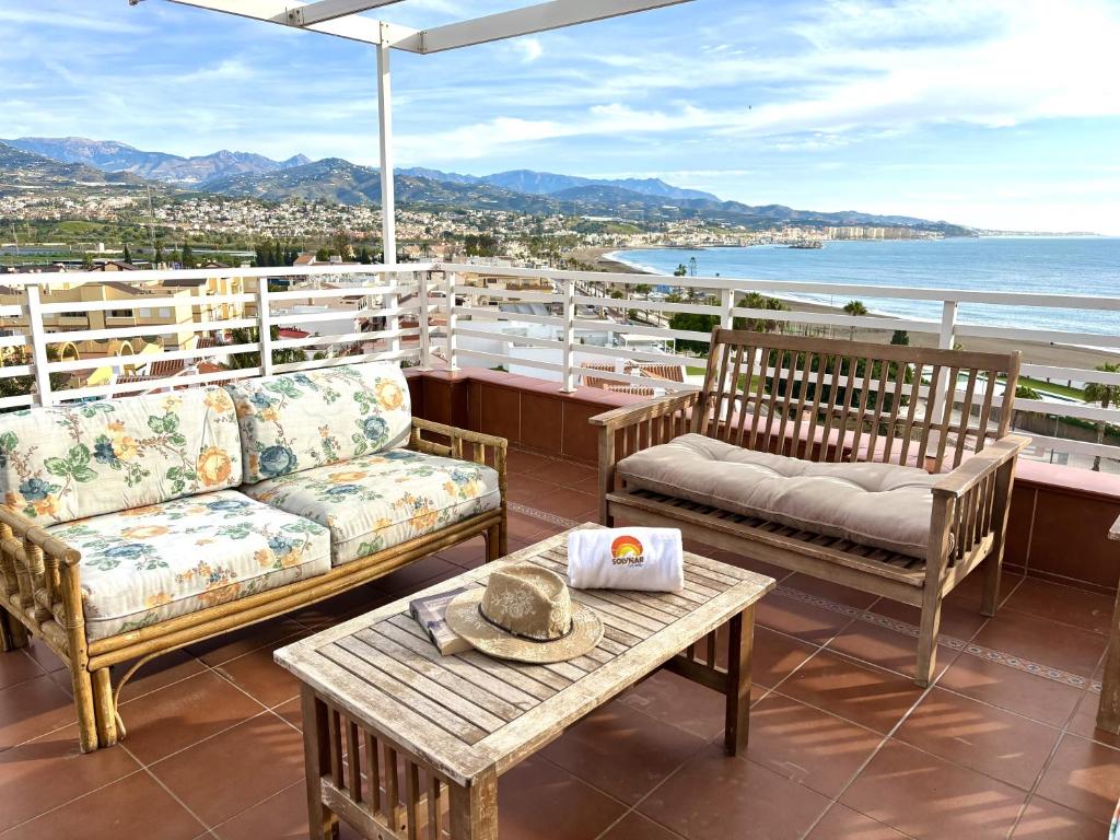 un patio con 2 sofás, una mesa y una sombrilla en Antillas XIII By Solymar Holiday, en Torre del Mar
