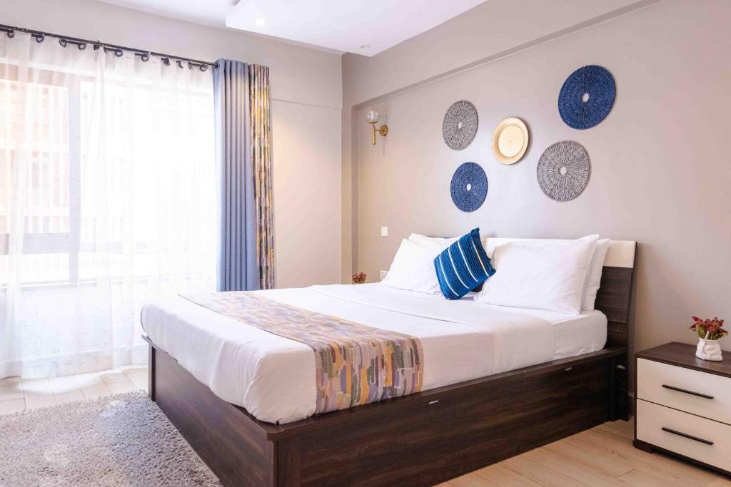 a bedroom with a large bed and a window at Wellivia Suites Serviced Apartments in Nairobi