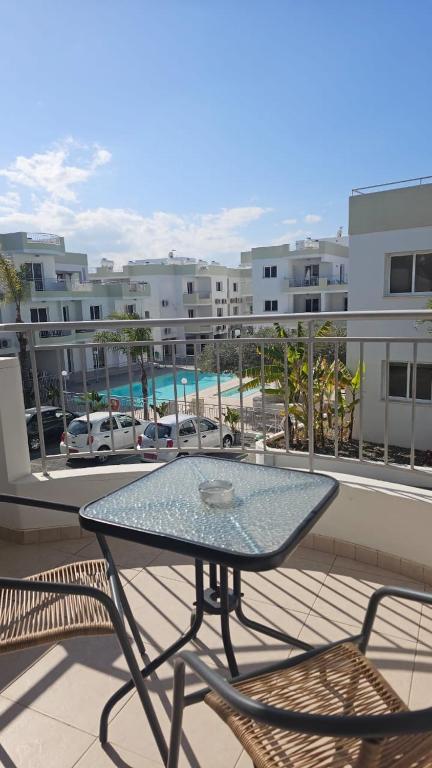 a glass table and chairs on a balcony with a view at Obv 3-206 in Pyla