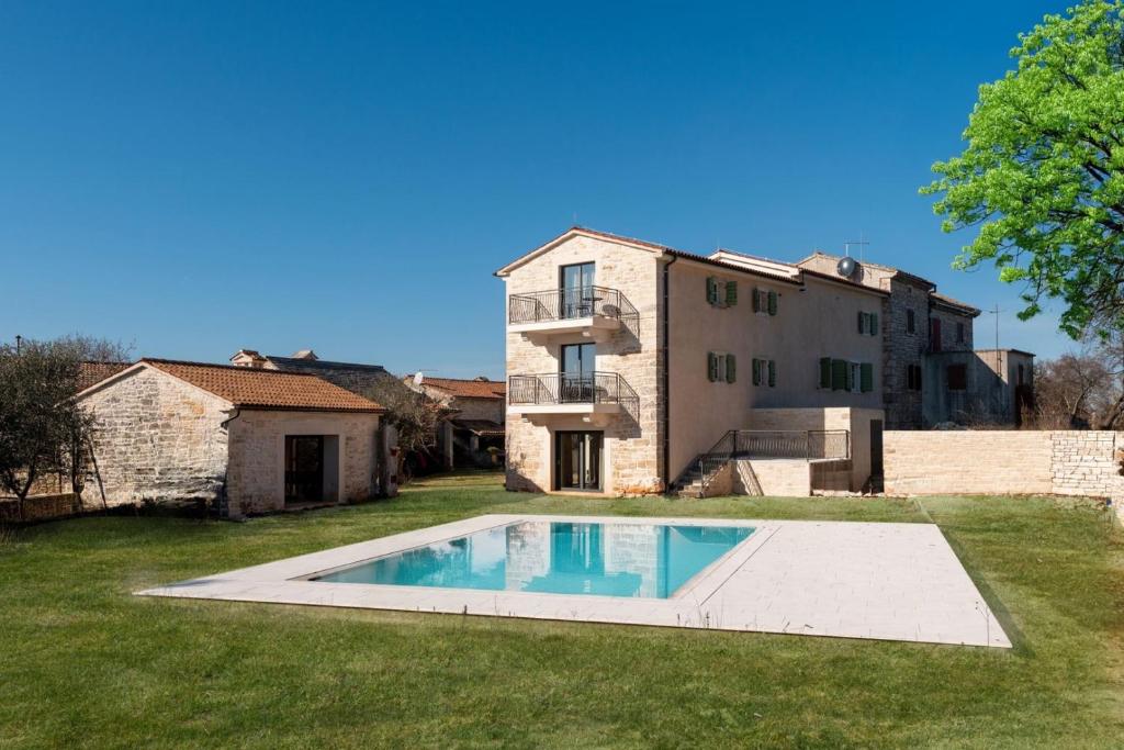 a house with a swimming pool in the yard at Villa Paladnjaki - breakfast included in Žminj