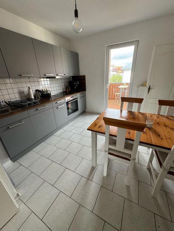 a kitchen with a wooden table and a table and chairs at Apartment-Luck Ilmenau in Ilmenau