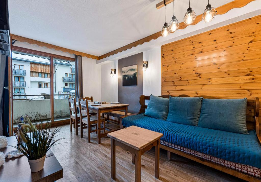 un salon avec un canapé bleu et une table dans l'établissement Résidence Les Hauts De Preclaux - Appartement exposé sud au coeur des Orres 1800 MAE-1651, aux Orres