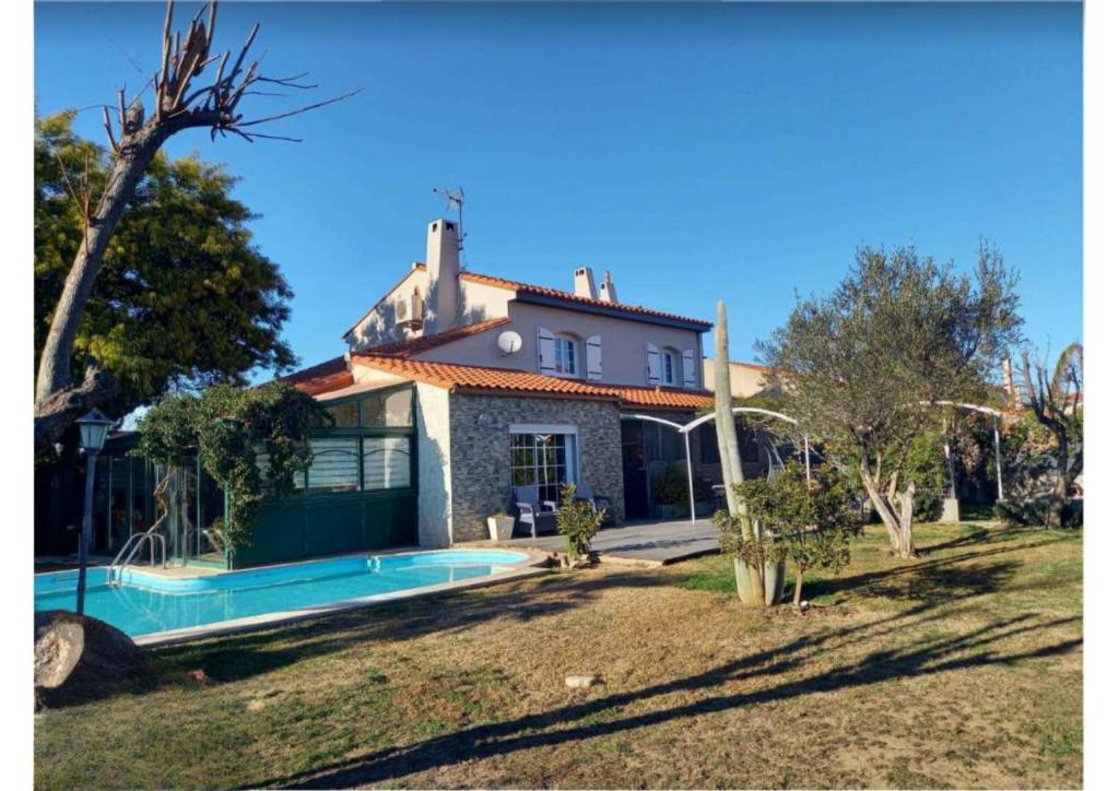 une maison avec une piscine devant dans l'établissement Magnifique maison Piscine et Spa 5mins des plages, à Elne