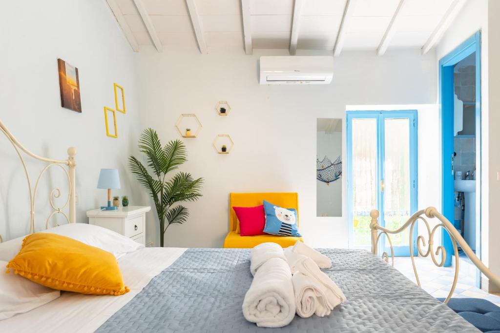 ein weißes Schlafzimmer mit einem Bett und einem orangefarbenen Stuhl in der Unterkunft Lago Trasimeno - La Casa del Pescatore - vicino a Perugia in San Feliciano