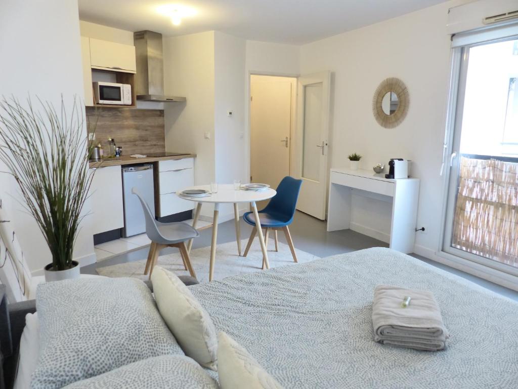 un salon avec un lit, une table et des chaises dans l'établissement Petit Mayence - Studio hyper-centre au calme, à Nantes