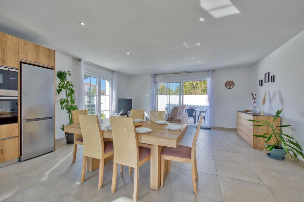 une cuisine et une salle à manger avec une table et des chaises dans l'établissement Maison Corail 3 - Parking privé proche plage, à Saint-Pierre-dʼOléron
