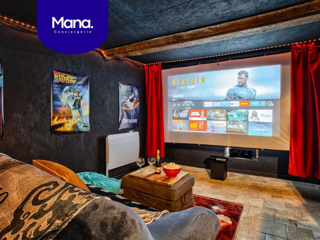 a living room with a large screen television at Cinéma Room - Salle vidéo projecteur - Netflix in Chicheboville