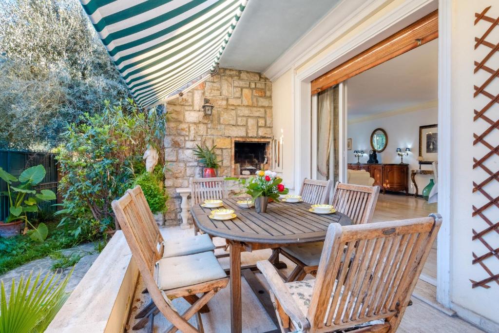 un patio avec une table, des chaises et une cheminée dans l'établissement Villa Eden, à Menton