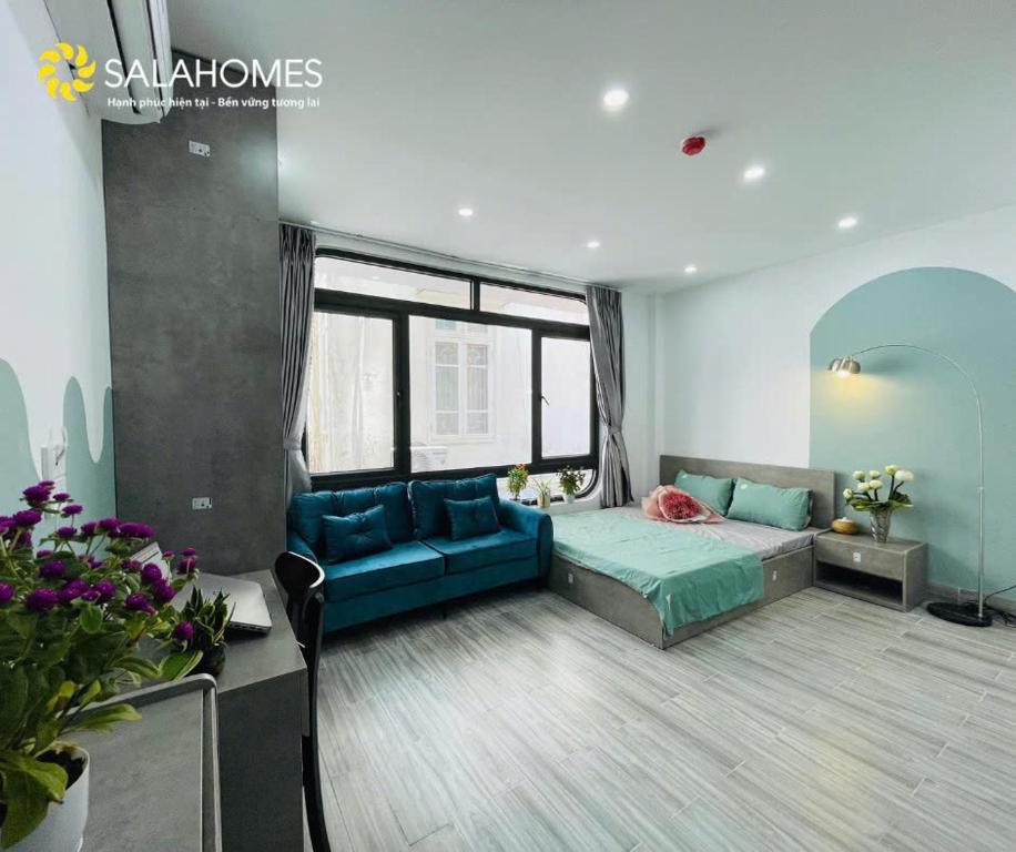 a bedroom with a bed and a blue couch at Salahomes Apartment by Dapano in Hanoi