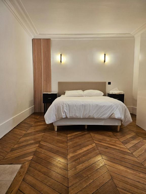 - une chambre avec un lit blanc et du parquet dans l'établissement Magnifique Appartement , 2 chambres, à Paris