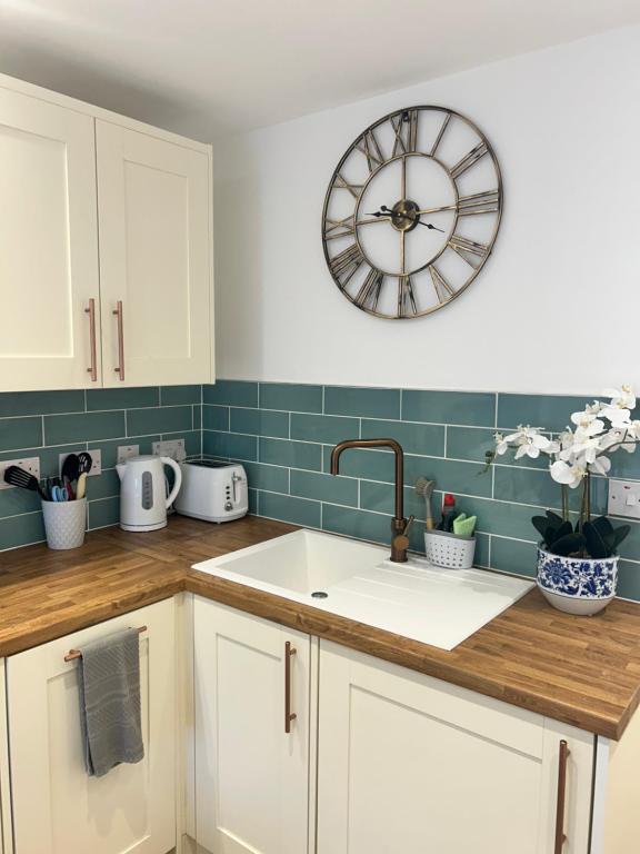 a kitchen with a sink and a clock on the wall at The Little Fern in Oxford
