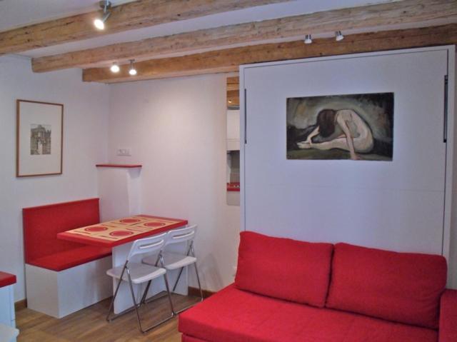 a living room with a red couch and a table at James Joyce - Metro Cubo in Trieste