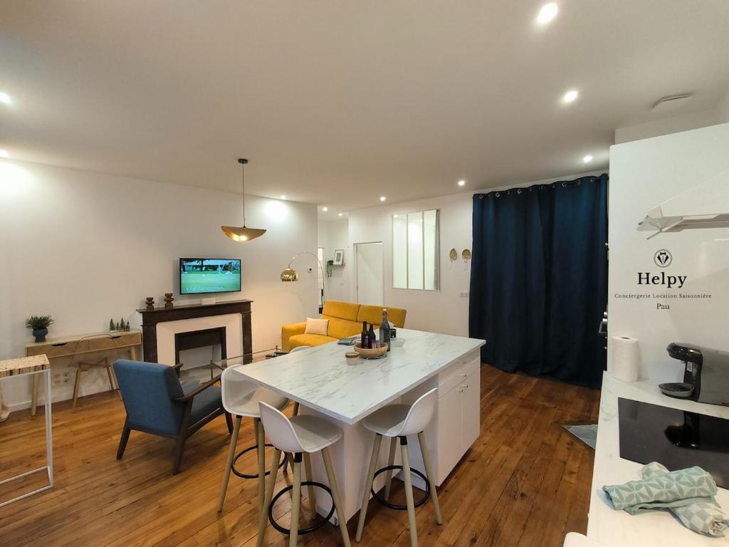 eine Küche und ein Wohnzimmer mit Tisch und Stühlen in der Unterkunft Henri IV in Pau