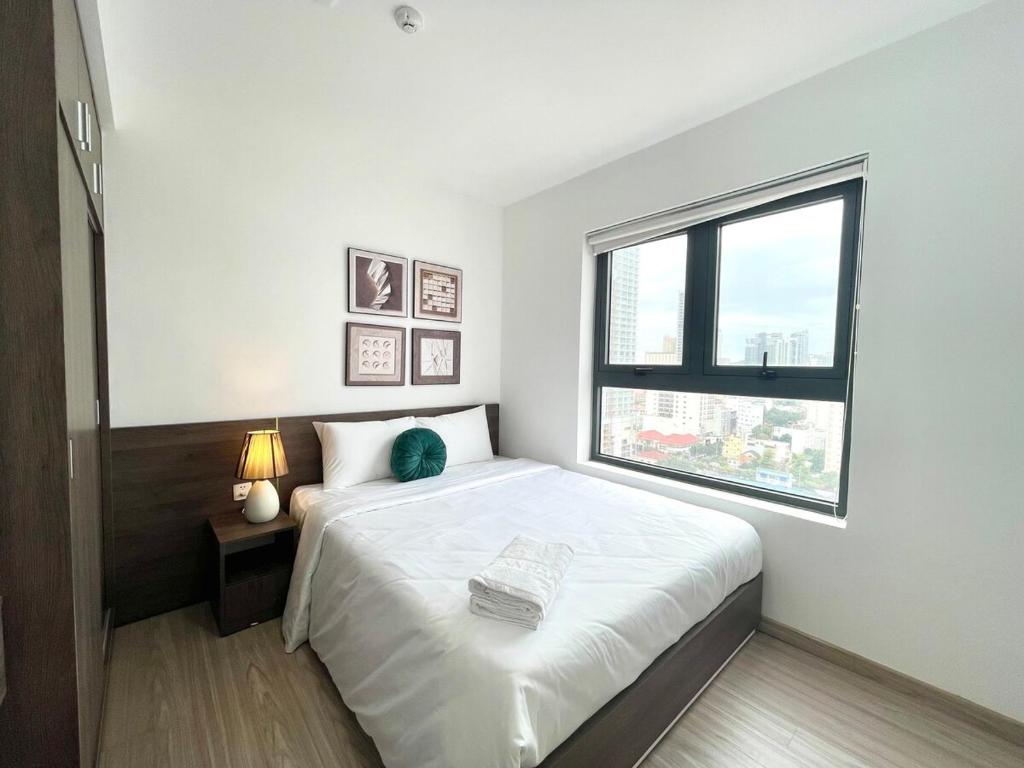 Un dormitorio blanco con una cama grande y una ventana. en 2BR - Dqua Hotel - Modern & Luxury Apt, en Nha Trang