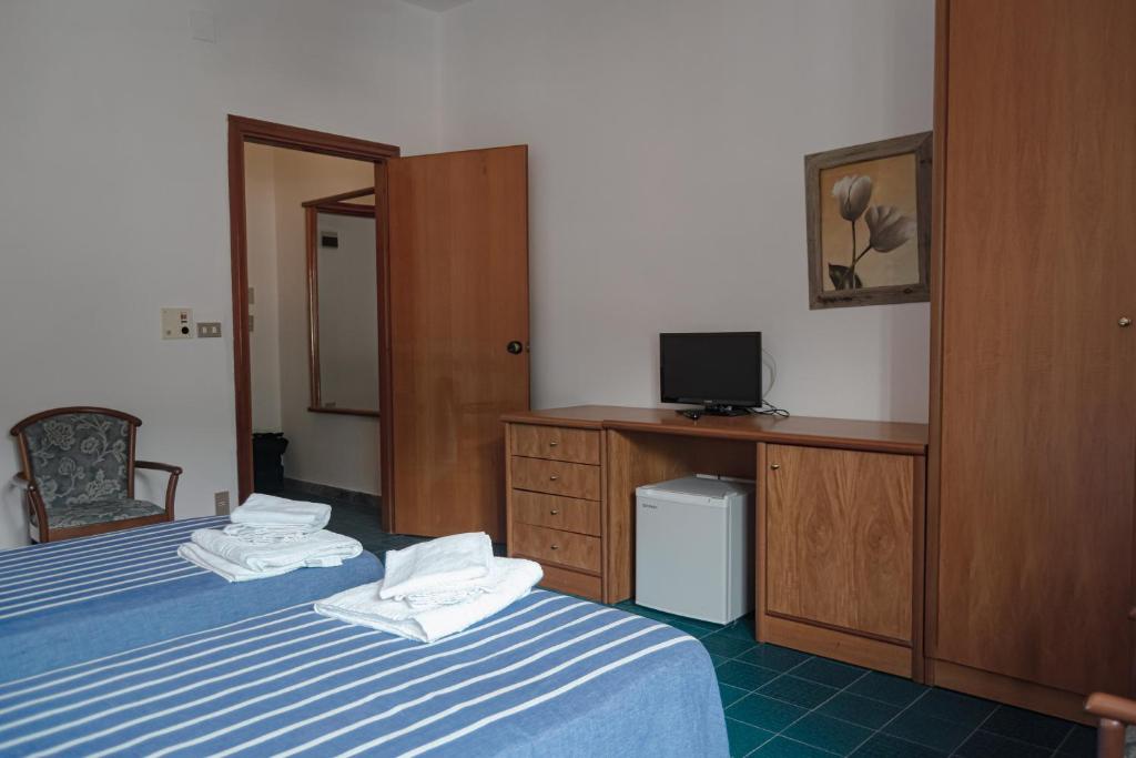Una habitación de hotel con dos camas y un televisor. en Hotel Mediterraneo, en Guardia Piemontese Terme