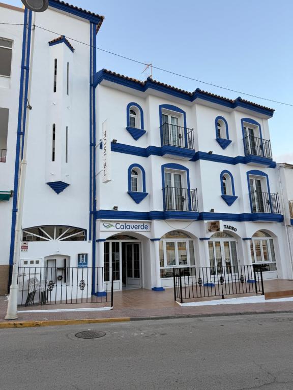 een groot wit gebouw met blauwe rand bij Hostal Calaverde in Villaricos