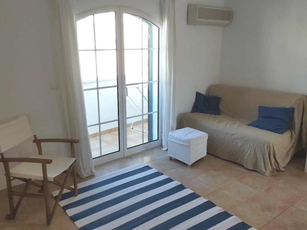 a living room with a couch and a window at Cozy Apartment Cabanas de Tavira in Cabanas de Tavira