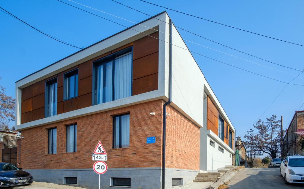 a red brick building with windows on a street at Villa in Avlabari in Tbilisi City
