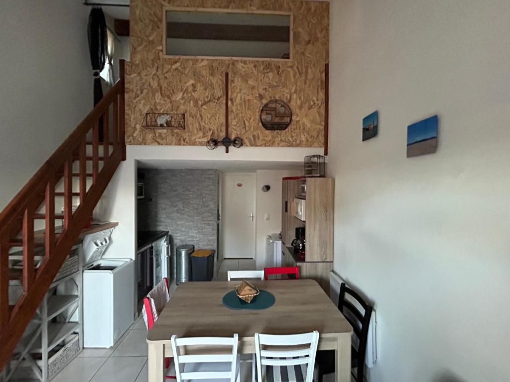 une salle à manger avec une table et des chaises et un escalier dans l'établissement Bonheur, à Saint Cyprien Plage