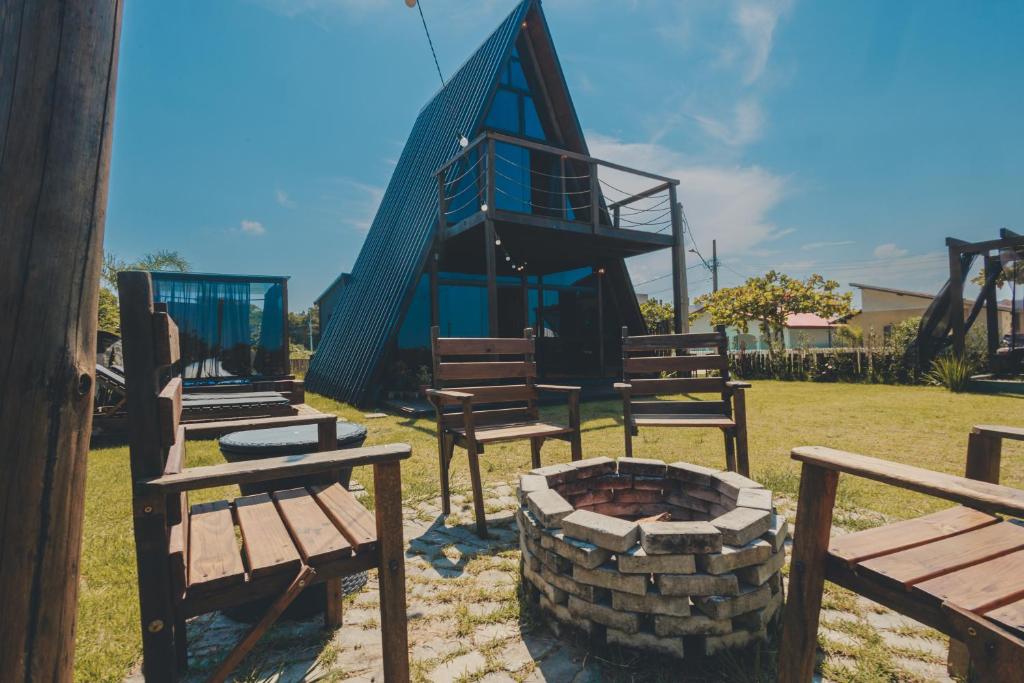 a group of benches and a building with a fire pit at Chalé Beira Mar Com Banheira com Vista in Itapoa
