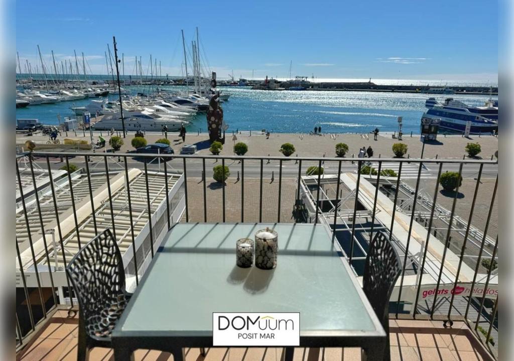 een tafel op een balkon met uitzicht op een jachthaven bij DOMuum Holidays - POSIT MAR in Cambrils