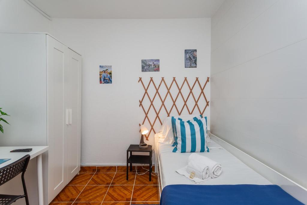 コスタ・ダ・カパリカにあるBeGuest Caparica Sun & Beachのベッドと机のある小さな寝室
