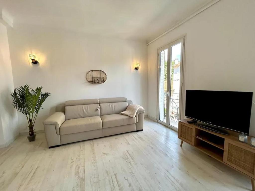un salon avec un canapé et une télévision à écran plat dans l'établissement Appartement moderne à Juans les Pins de 60 m² avec parking, à Juan-les-Pins